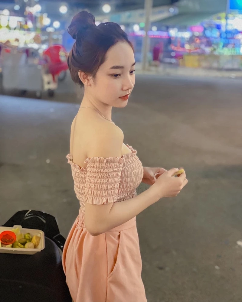 Hình cô gái che mặt bằng lá cây thể hiện sự tự nhiên và duyên dáng